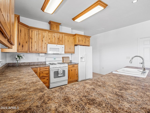 kitchen featuring white appliances and a sink