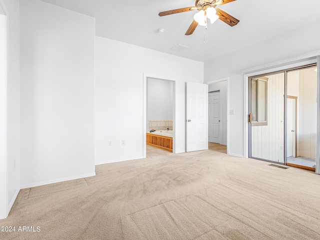 unfurnished bedroom with visible vents, light colored carpet, connected bathroom, and baseboards