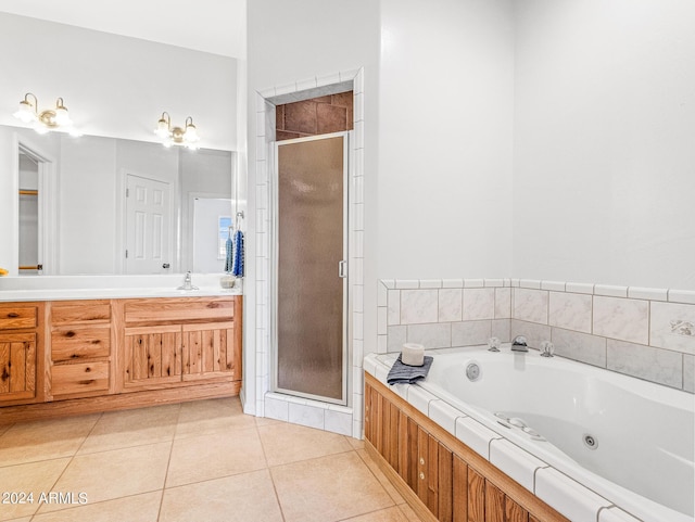 full bathroom with vanity, a tub with jets, a shower stall, and tile patterned flooring