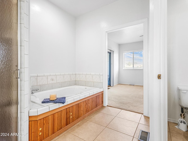 bathroom featuring tile patterned floors, visible vents, toilet, and a bath