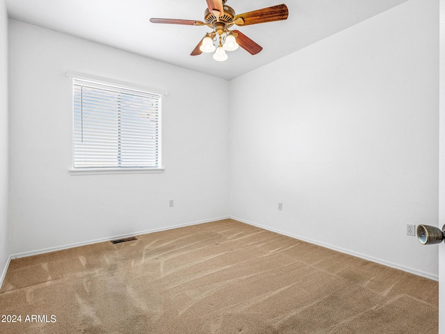 spare room featuring baseboards, visible vents, a ceiling fan, and carpet