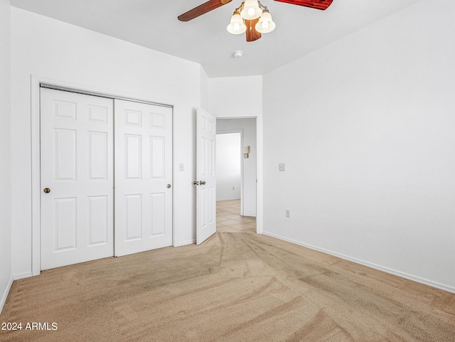 unfurnished bedroom featuring ceiling fan, carpet, a closet, and baseboards