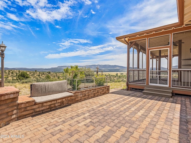 view of patio with a mountain view and a sunroom