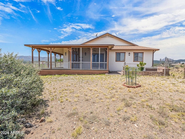 rear view of property featuring a mountain view and a sunroom