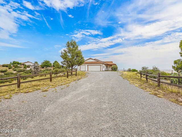 view of front of property with driveway, an attached garage, and fence