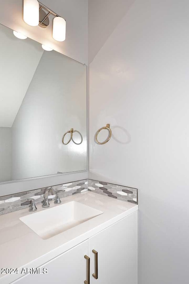 bathroom featuring vanity and lofted ceiling