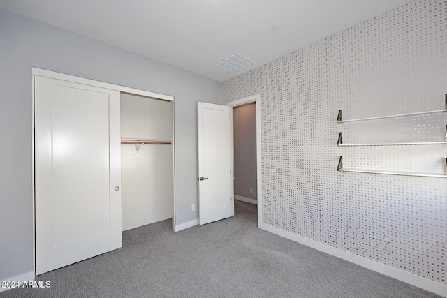 unfurnished bedroom featuring light carpet and a closet