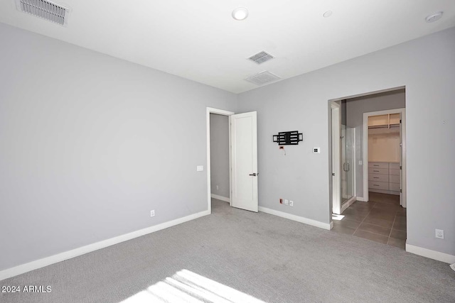 unfurnished bedroom featuring a walk in closet, carpet floors, and a closet