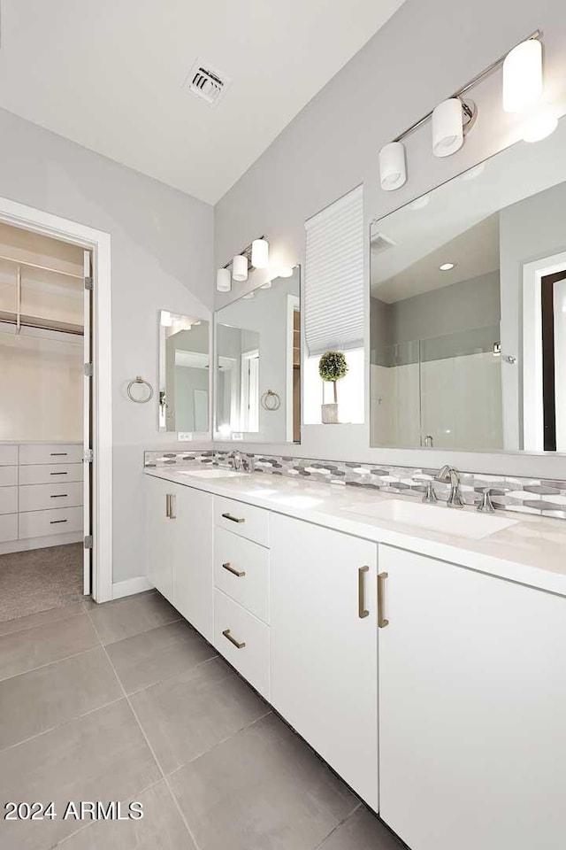 bathroom with tile patterned flooring, vanity, and a shower with door