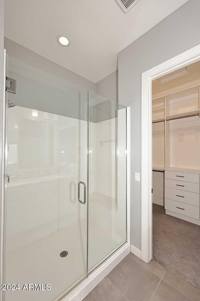 bathroom featuring tile patterned floors and a shower with shower door