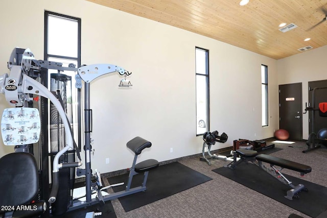 workout area with carpet flooring and wood ceiling