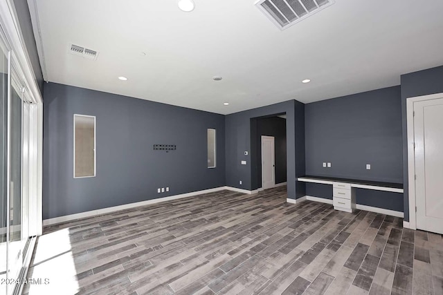 interior space featuring built in desk and wood-type flooring