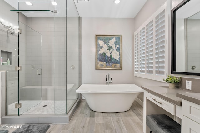 bathroom with vanity, hardwood / wood-style floors, and independent shower and bath