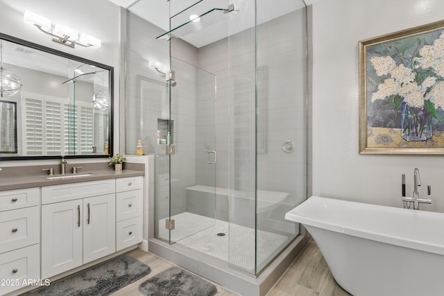 bathroom with vanity, separate shower and tub, and hardwood / wood-style floors