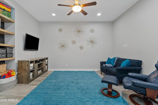 living area with ceiling fan and light hardwood / wood-style floors