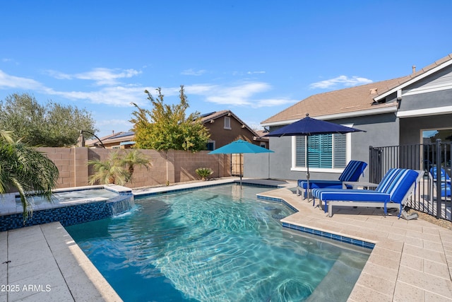 view of pool with a patio area, pool water feature, and an in ground hot tub