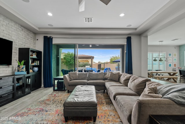 living room featuring an inviting chandelier and light wood-type flooring