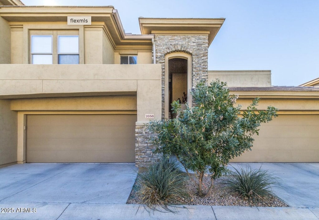 20121 N 76th St Unit 2058, Scottsdale, AZ 85255 - view of front of home featuring stone siding, stucco siding, and driveway