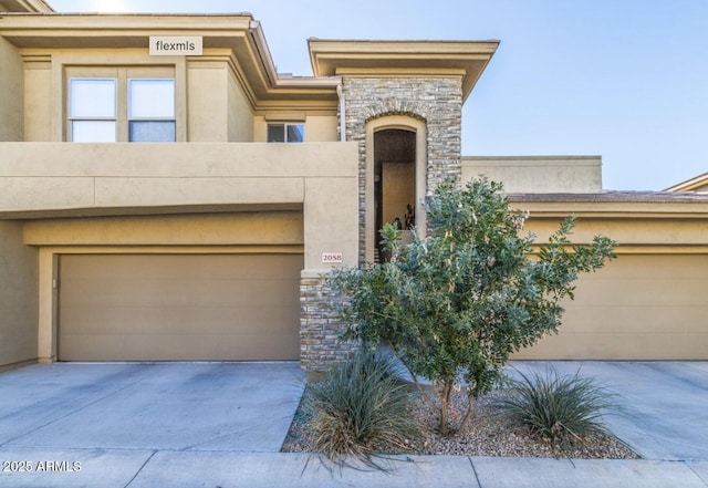 20121 N 76th St Unit 2058, Scottsdale, AZ 85255 - view of front of home featuring stone siding, stucco siding, and driveway