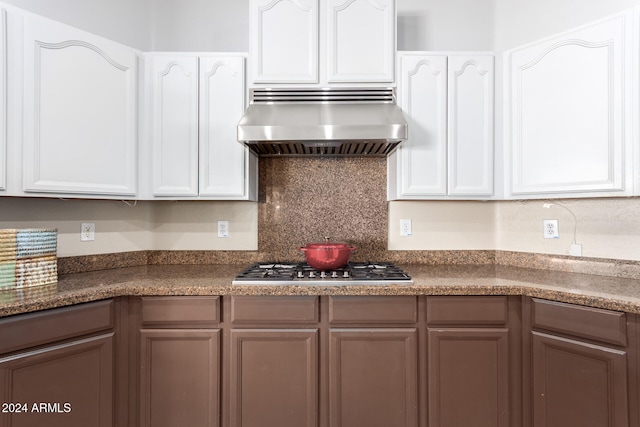 kitchen with stainless steel gas cooktop, exhaust hood, backsplash, and white cabinets