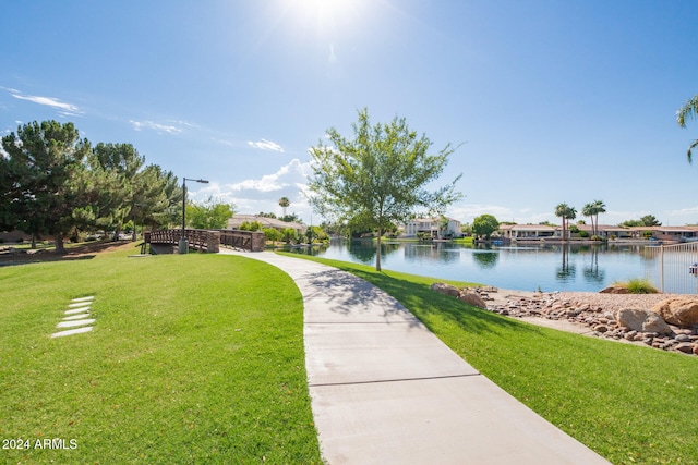 view of property's community with a yard and a water view