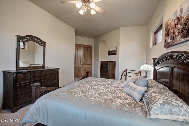 bedroom with light carpet, arched walkways, and ceiling fan