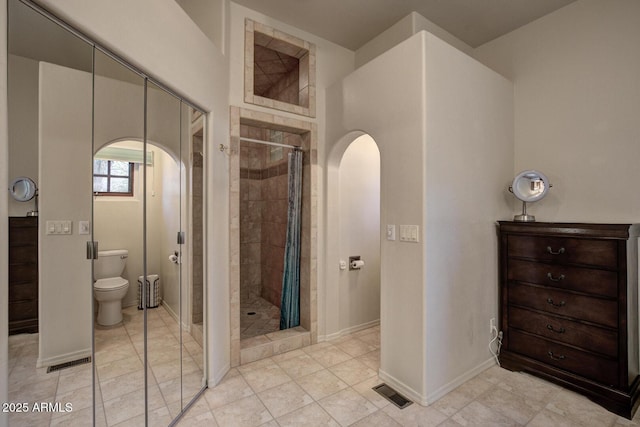 bathroom featuring baseboards, visible vents, tile patterned flooring, a shower stall, and toilet