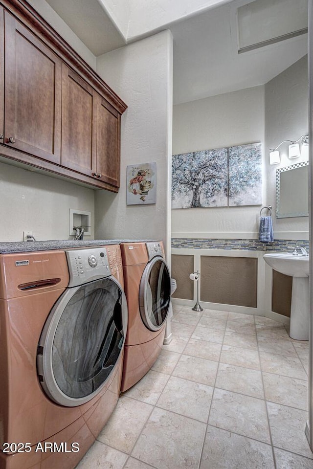 laundry area with a sink, cabinet space, and separate washer and dryer