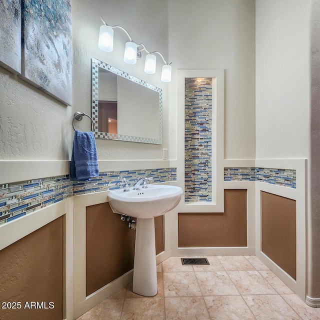 bathroom with tile patterned floors, decorative backsplash, and visible vents