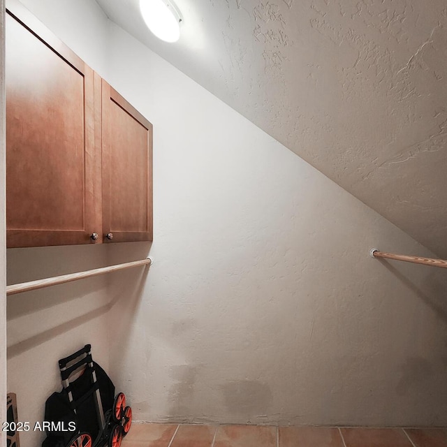 walk in closet featuring tile patterned floors and lofted ceiling