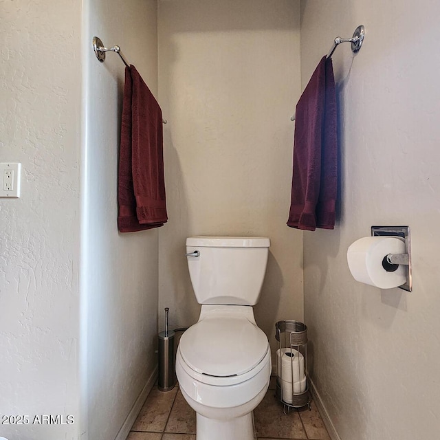 bathroom featuring tile patterned floors, toilet, and baseboards