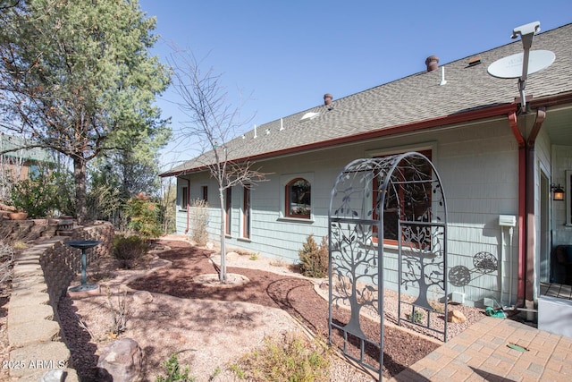 exterior space featuring roof with shingles