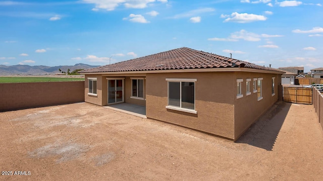 17841 W Windsor Blvd, Litchfield Park, AZ 85340 - back of house with a mountain view, stucco siding, a fenced backyard, a tiled roof, and a patio area