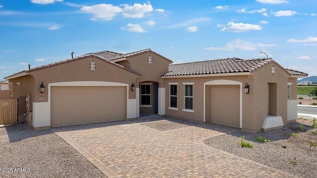 17841 W Windsor Blvd, Litchfield Park, AZ 85340 - mediterranean / spanish-style house with stucco siding, a tile roof, decorative driveway, an attached garage, and fence