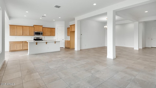 17841 W Windsor Blvd, Litchfield Park, AZ 85340 - kitchen featuring appliances with stainless steel finishes, open floor plan, light countertops, recessed lighting, and a kitchen breakfast bar