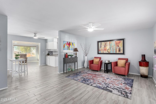 sitting room with light wood-type flooring and ceiling fan