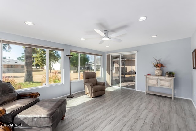 sitting room with ceiling fan and light wood-type flooring