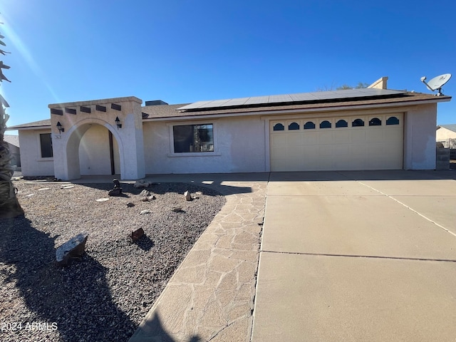 view of front facade featuring solar panels and a garage