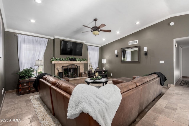 living room featuring ceiling fan, ornamental molding, a fireplace, and vaulted ceiling