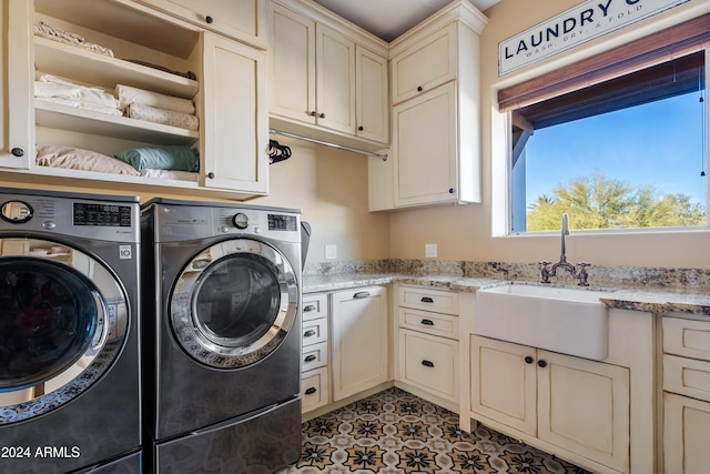 washroom featuring cabinet space, washer and clothes dryer, and a sink