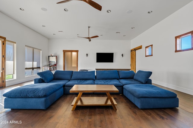 living room with dark wood-style floors, a barn door, a ceiling fan, and recessed lighting