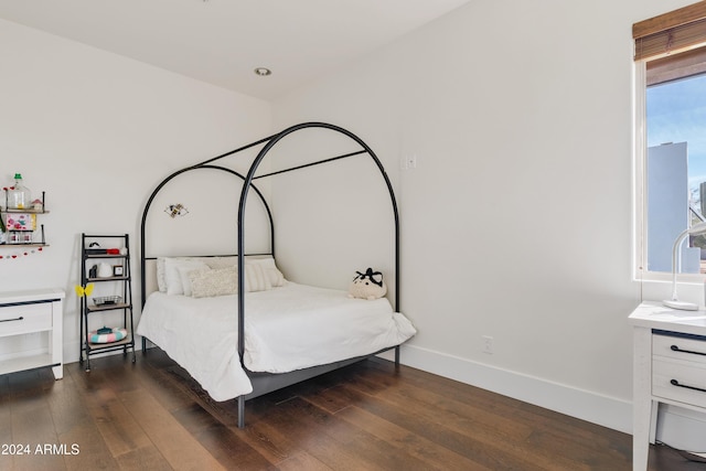 bedroom with baseboards and dark wood finished floors