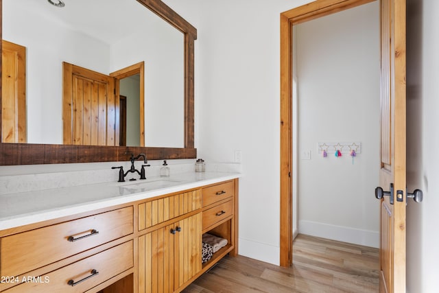 bathroom featuring wood finished floors, vanity, and baseboards