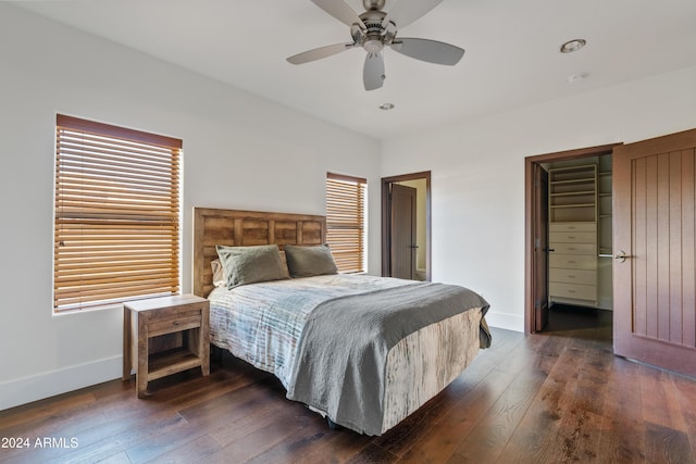 bedroom featuring ceiling fan, multiple windows, baseboards, and dark wood finished floors