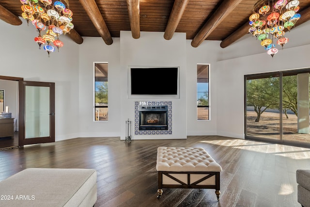 living area featuring beam ceiling, dark wood-style flooring, a fireplace, and wooden ceiling