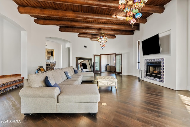 living area featuring wooden ceiling, arched walkways, wood finished floors, and a tile fireplace