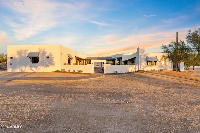 adobe home featuring fence and stucco siding