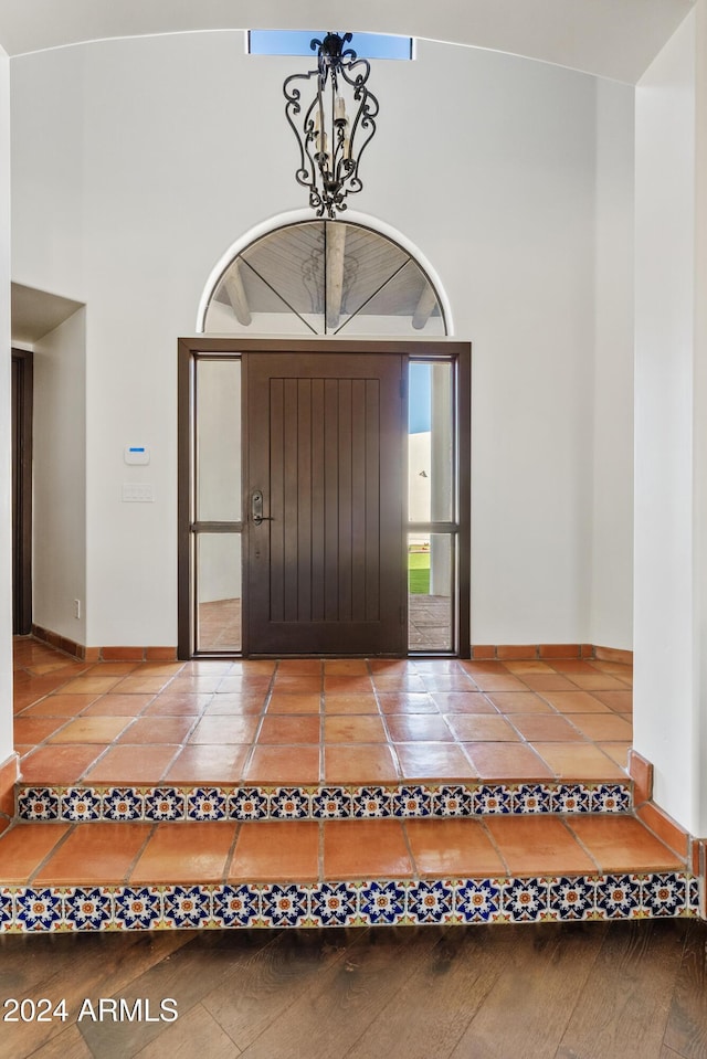 entrance foyer featuring tile patterned flooring, a high ceiling, and baseboards