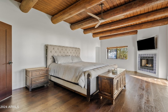 bedroom with a tile fireplace, wooden ceiling, dark wood finished floors, and beam ceiling