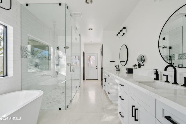 bathroom featuring double vanity, a freestanding tub, a sink, and a shower stall